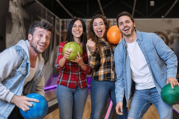 Friends playing competitive bowling match