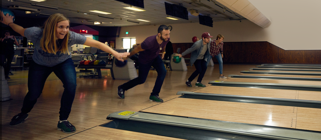 Competitive bowling match between friends