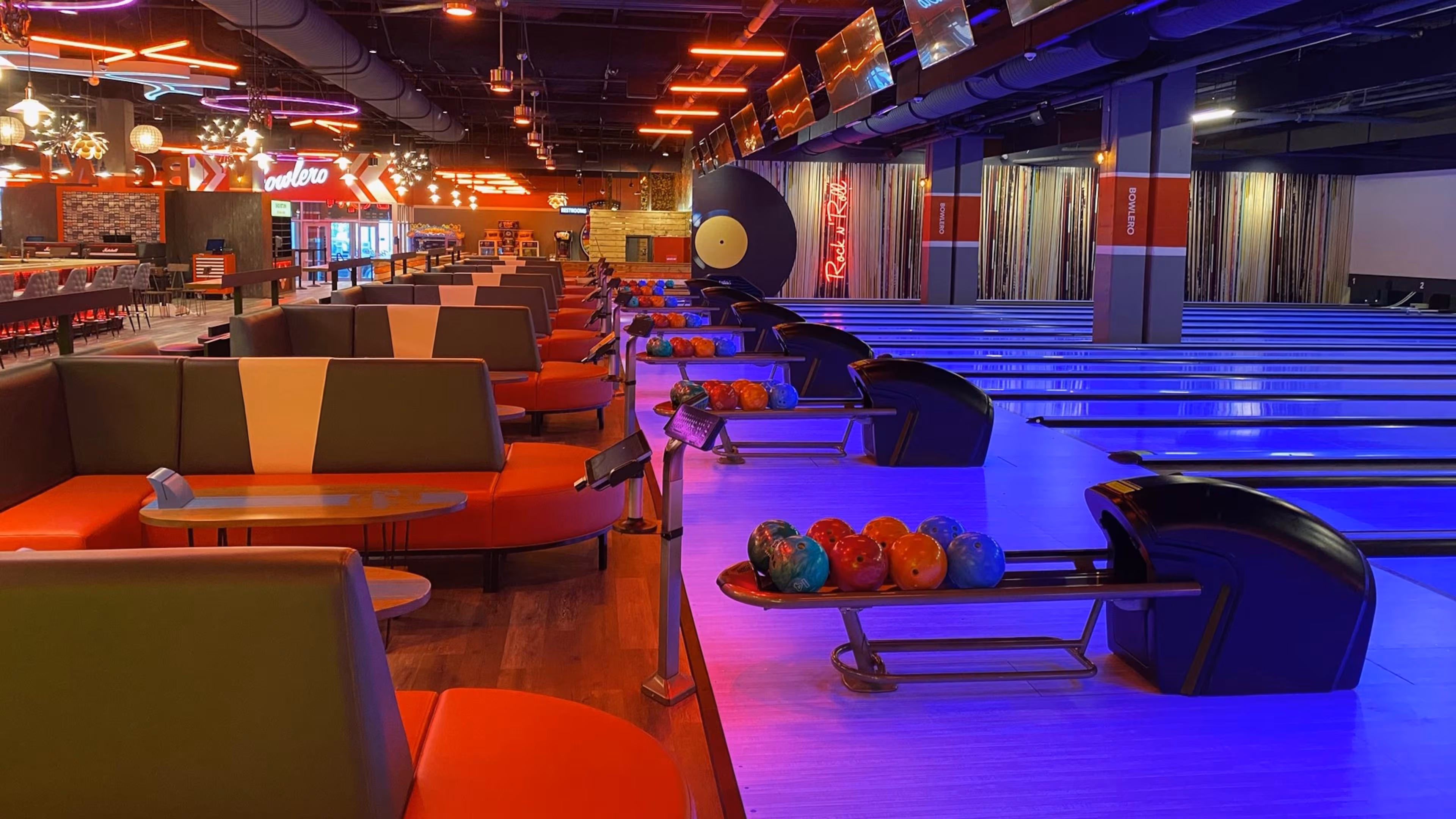 Modern bowling center interior with illuminated lanes and seating