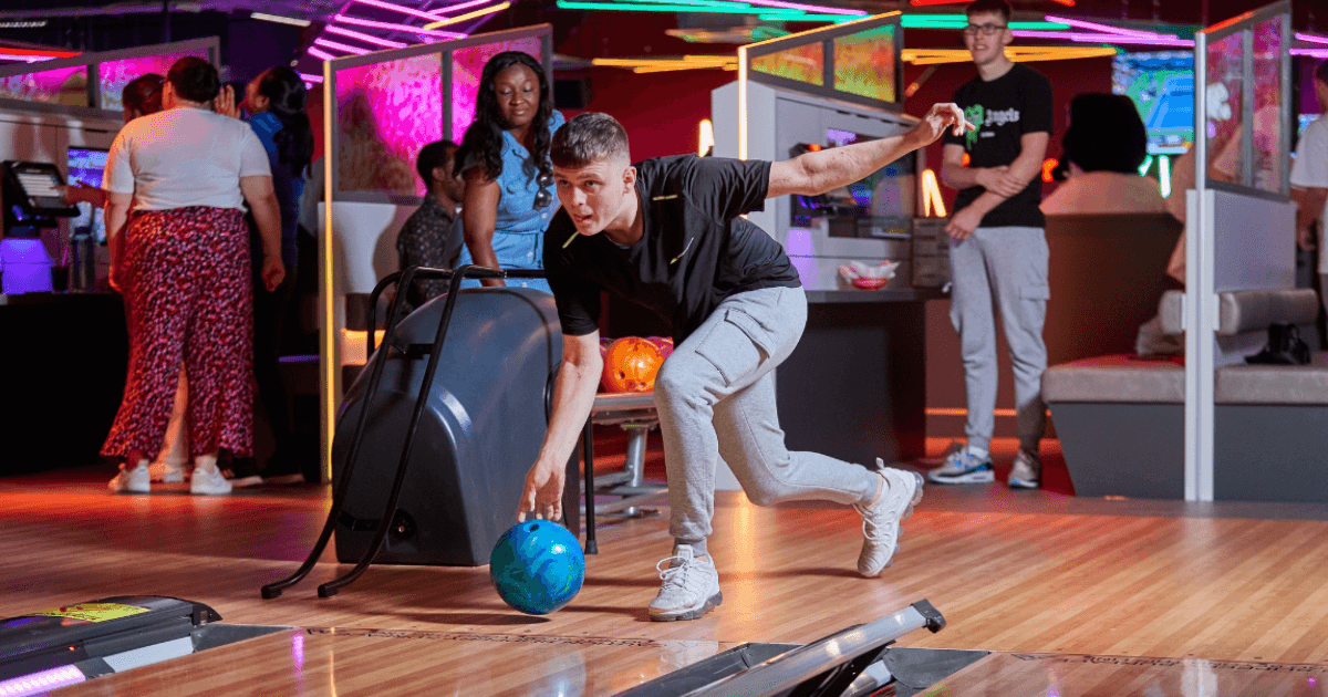 Staff member assisting a bowling player with technique